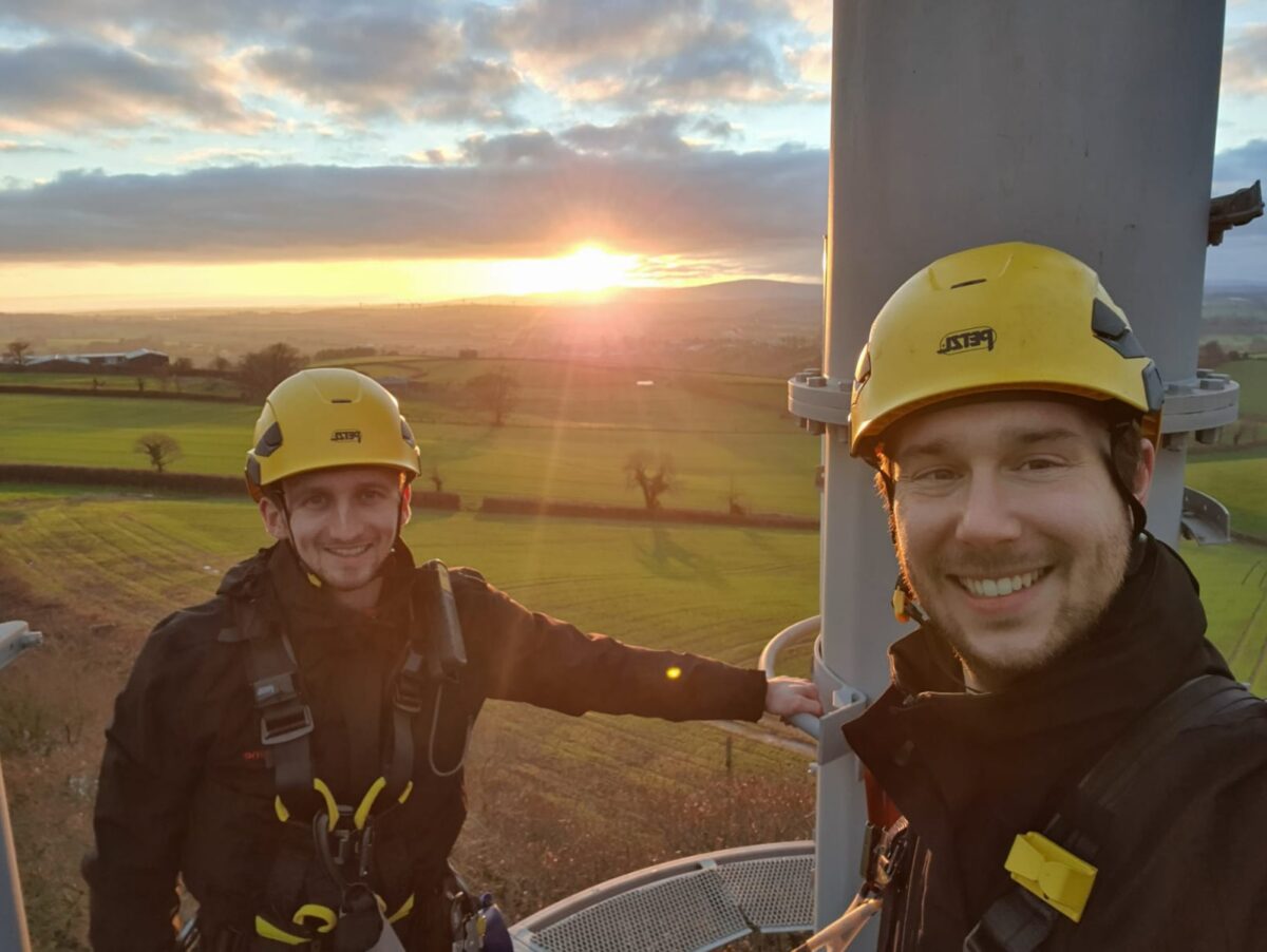 Lewis and a coworker at the top of a telephone mast